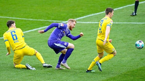 Osnabrücks Sebastian Kerk (M.) versucht, sich gegen die Braunschweiger Dominik Wydra (l.) und Lasse Schlüter durchzusetzen. © IMAGO / Nico Paetzel 