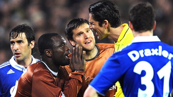 St. Paulis Gerald Asamoah (2.v.l.) und Florian Bruns (M.) sprechen mit Schiedsrichter Deniz Aytekin. © dpa 