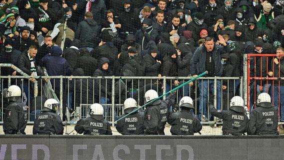 Polizisten werden im Millerntorstadion aus dem Gästeblock mit Stangen beworfen. © Witters 