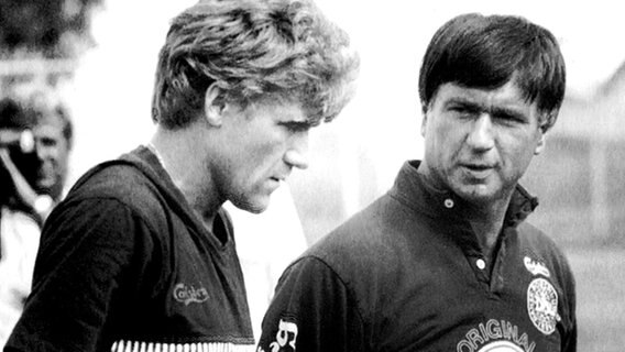 Dänemarks Nationaltrainer Morten Olsen (r.) im Gespräch mit seinem Kapitän Morten Olsen während der WM 1986. © picture-alliance/ dpa 