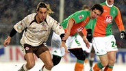 St. Paulis Felix Luz im Duell mit dem Bremer Frank Baumann (r.). Szene aus dem Pokalspiel 2006. © picture-alliance 