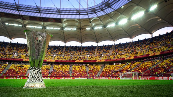 Der Europa-League-Pokal steht auf dem Rasen eines Fußball-Stadions. © Witters Foto: Matthew Ashton