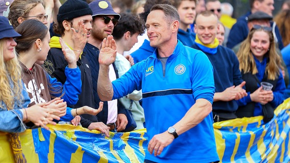 Trainer Jörn Großkopf vom FC Alsterbrüder wird von den Fans des Oberliga-Aufsteigers gefeiert © IMAGO / Lobeca 
