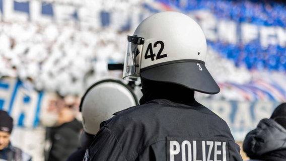Ein Polizist trägt einen Helm mit der Aufschrit "42". © IMAGO / Philipp Szyza 