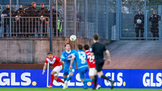 Mehrere Polizisten beobachten das Drittliga-Spiel zwischen Rot-Weiss Essen und Hansa Rostock © IMAGO/Maximilian Koch 