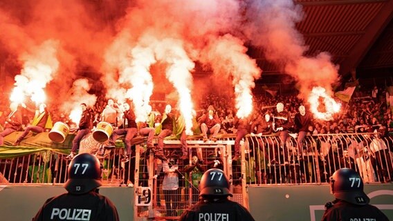 Wolfsburger Fans zünden beim Pokalspiel in Braunschweig Pyrotechnik. © IMAGO / Eibner 