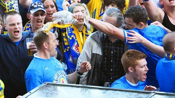 Braunschweigs Coach Torsten Lieberknecht (l.) bekommt eine Bierdusche © fishing4 