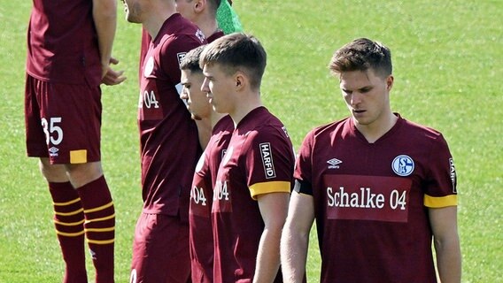 Schalke Spieler zur Schweigeminute zum Krieg in der Ukraine ohne Trikotsponsor. © picture alliance/dpa 