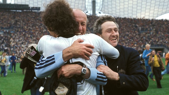Bundestrainer Helmut Schön umarmt Franz Beckenbauer nach dem WM-Triumph 1974. © picture-alliance 