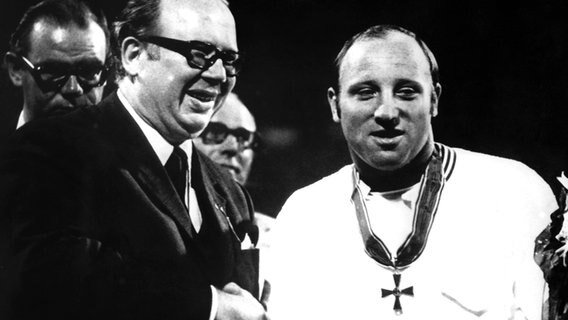 Uwe Seeler (r.) bekommt 1970 vor seinem letzten Länderspiele von Innen-Staatssekretär Wolfram Dorn das Bundesverdienstkreuz verliehen. © picture alliance / dpa 