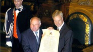 Hamburgs Erster Bürgermeister Ole von Beust (r.) überreicht Uwe Seeler die Urkunde, die ihn als Ehrenbürger der Hansestadt auszeichnet. © dpa 
