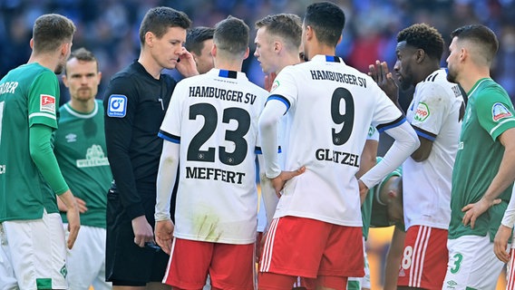 Schiedsrichter Daniel Siebert im Nordderby umringt von den Spielern des HSV und Werder Bremen © Witters 