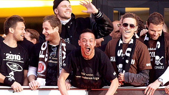 Die St.-Pauli-Spieler feiern auf dem Balkon des "Schmidts Tivoli" auf dem Kiez. © dpa 