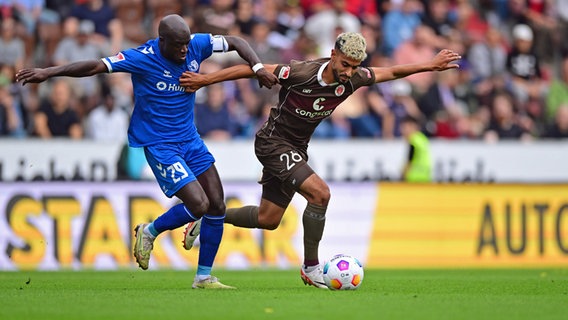 Magdeburgs Amara Condé (l.) und St. Paulis Elias Saad kämpfen um den Ball. © Witters 