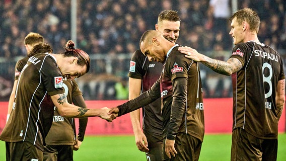 Jackson Irvine, Etienne Amenyido, Hauke Wahl und Eric Smith (v.l.) feiern den Sieg gegen den 1. FC Nürnberg. © IMAGO / Eibner 