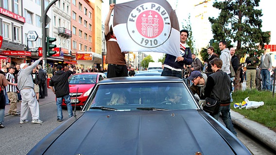 Mit einem Autokorso feiern die Fans vom FC St. Pauli ihre Mannschaft am Sonntag auf der Hamburger Reeperbahn. © dpa 