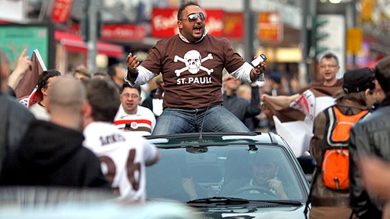 Mit einem Autokorso feiern die Fans vom FC St. Pauli ihre Mannschaft am Sonntag auf der Hamburger Reeperbahn. © dpa 