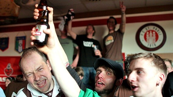 Fans vom FC St. Pauli feiern den Aufstieg in einer Kneipe auf der Hamburger Reeperbahn. © dpa 