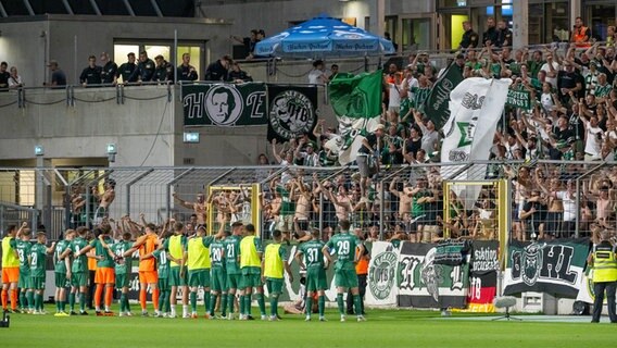 Das Team des VfB Lübeck feiert nach dem Sieg bei 1860 München mit seinen Fans © picture alliance 