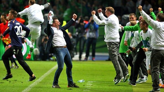 Wolfsburgs Trainer Dieter Hecking (M.) jubelt über den Pokalsieg. © dpa - Bildfunk Foto: Kay Nietfeld