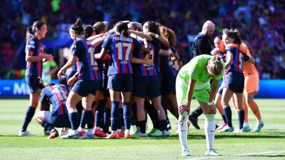 Wolfsburgs Alexandra Popp ist enttäuscht, während im Hintergrund Barcelonas Spielerinnen den Finalsieg bejubeln. © IMAGO / Revierfoto 