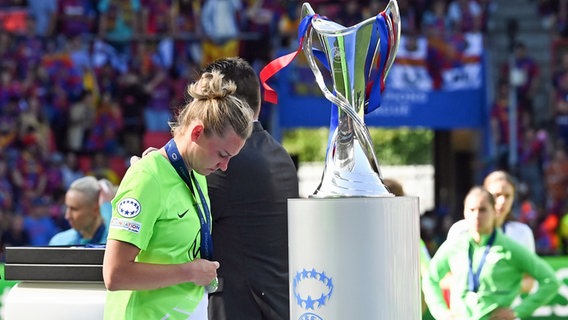 Wolfsburgs Alexandra Popp läuft nach der Finale-Niederlage enttäuscht am Champions-League-Pokal vorbei. © picture alliance/dpa | Swen Pförtner 