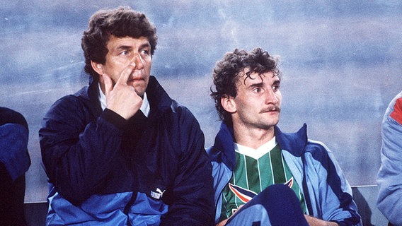 Rudi Völler sitzt neben Werder Bremens Trainer Otto Rehhagel auf der Ersatzbank. © picture-alliance 