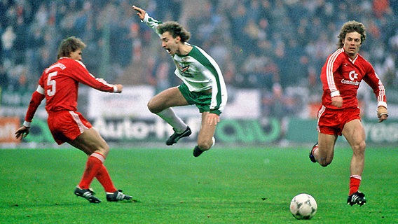 Bayern-Kapitän Klaus Augenthaler (l.) foult am 23. November 1985 in München Rudi Völler (M.). Der Bremer Stürmer fällt danach fünf Monate verletzt aus. © imago/WEREK Foto: imago