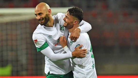 Werder Bremens Fußballer Ömer Toprak (l.) und Leonardo Bittencourt umarmen sich. © IMAGO / Zink 