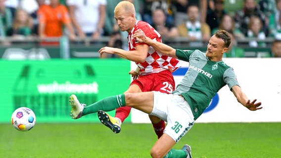 Werders Christian Groß (r.) im Zweikampf mit Andreas Hanche-Olsen von Mainz 05 © IMAGO/Nordphoto 