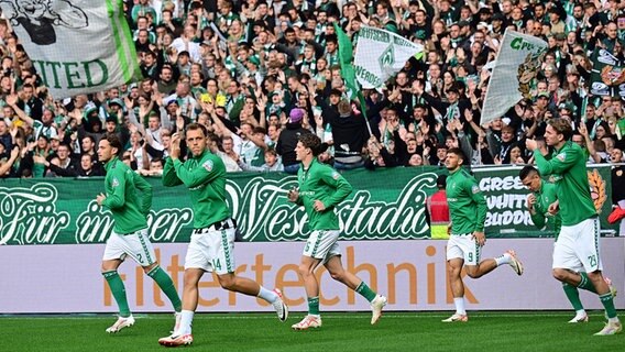 Werders Spieler laufen auf das Feld. © picture alliance / dpa 