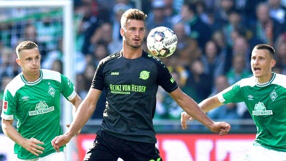 Hannovers Hendrik Weydandt (M.) setzt sich gegen zwei Gegenspieler durch. © imago/Team 2 