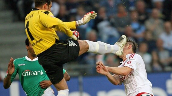 Werder-Keeper Tim Wiese (l.) trifft Ivica Olic vom HSV mit den Stollen voran im Gesicht. © Witters 