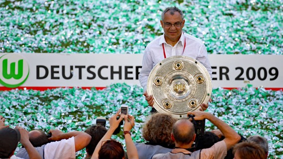 Wolfsburgs Trainer Felix Magath präsentiert die Meisterschale. © picture-alliance/ dpa Foto: Kay Nietfeld