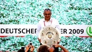 Wolfsburgs Trainer Felix Magath präsentiert die Meisterschale. © dpa 