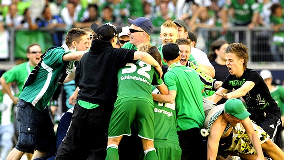 Die Wolfsburger Spieler feiern mit ihren Fans. © dpa 