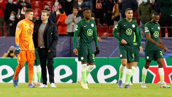 Wolfsburgs Trainer Florian Kohfeldt geht nach dem Spiel in Sevilla zusammen mit Wolfsburgs Torwart Pavao Pervan (links) vom Platz. © dpa-Bildfunk 