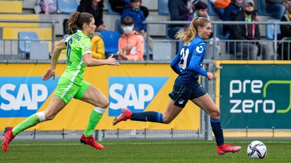 Wolfsburgs Kapitänin Dominique Janssen (l.) verfolgt ihre Hoffenheimer Gegenspielerin Jule Brand. © IMAGO / foto2press 