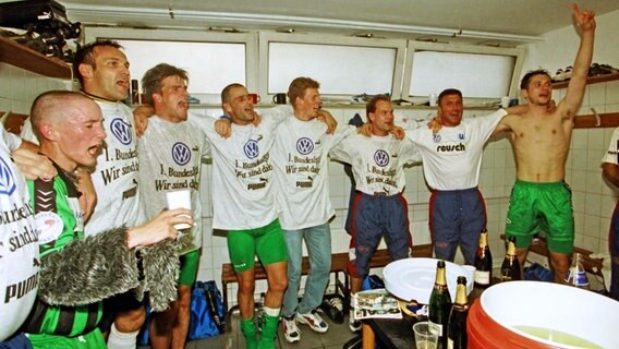 Die Wolfsburger Spieler feiern am 11. Juni 1997 in der Kabine den Aufstieg. © IMAGO / Rust 