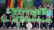 Wolfsburger Spielerinnen mit dem Champions-League-Pokal, dem DFB-Pokal und mit der Deutschen Meisterschale © Imago/Hübner 