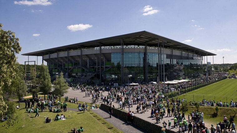 Wolfsburger Fans vor der Volkswagen Arena in Wolfsburg, Heimspielstätte des VfL Wolfsburg Fußball 1. BL Herren Saison 2008 2009, VfL Wolfsburg Totale VolkswagenArena Wolfsburg © IMAGO / Ulmer