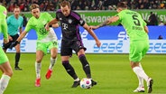 Wolfsburgs Lovro Majer (l.) und Cedric Zesiger (r.) versuchen, Bayerns Harry Kane zu stoppen. © IMAGO / Jan Huebner 
