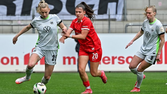 Freiburgs Leela Egli (M.) versucht, Wolfsburgs Sarai Linder (l.) vom Ball zu trennen. © picture alliance / Eibner-Pressefoto 
