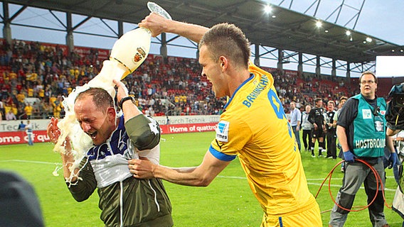 Braunschweigs Trainer Torsten Lieberknecht (l.) bekommt von Orhan Ademi eine Bierdusche. © Fishing4 