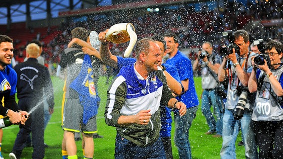 Braunschweigs Trainer Torsten Lieberknecht (M.) bekommt eine Bierdusche. © dpa - Bildfunk Foto: Andreas Gebert