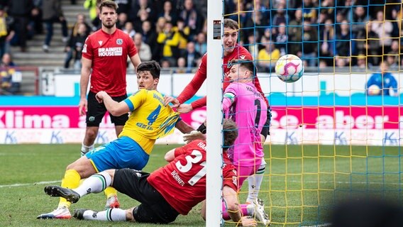 Braunschweigs Jannis Nikolaou (l.) trifft gegen Hannover. © picture alliance/dpa | Swen Pförtner 