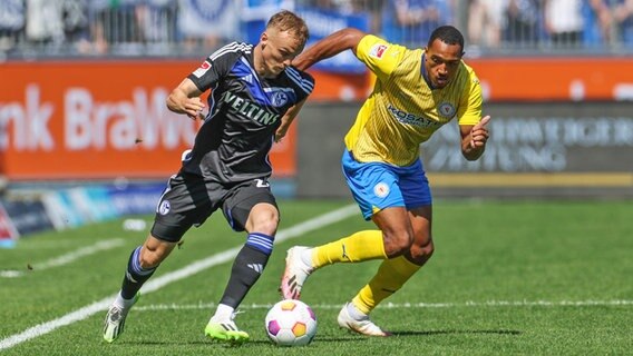 Braunschweigs Anton Donkor (r.) und Schalkes Niklas Tauer kämpfen um den Ball. © IMAGO / RHR-Foto 