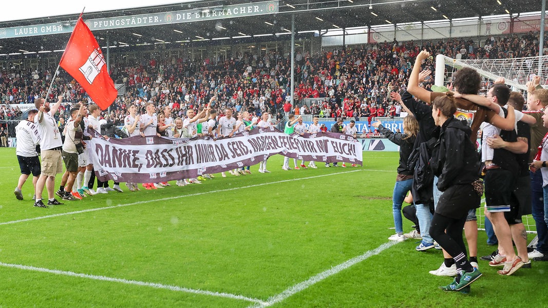 St. Paulis mitgereiste Anhänger bejubeln mit den Spielern die Meisterschaft in der Zweiten Bundesliga.