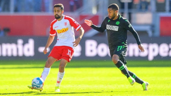 Hannovers Linton Maina (r.) und Regensburgs Sarpreet Singh kämpfen um den Ball. © IMAGO / Passion2Press 