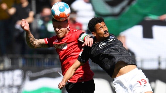 Hannovers Marcel Franke und Düsseldorfs Emmanuel Iyoha kämpfen um den Ball. © picture alliance/dpa | Daniel Reinhardt 